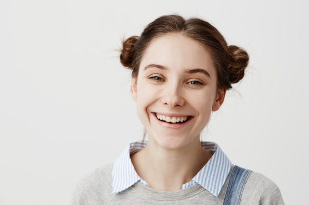 Nahaufnahme Kopfschuss der absolut glücklichen Frau, die mit breitem Lächeln kichert. Freudige Gefühle einer unbeschwerten Studentin, die nach bestandener Prüfung gute Laune hat.