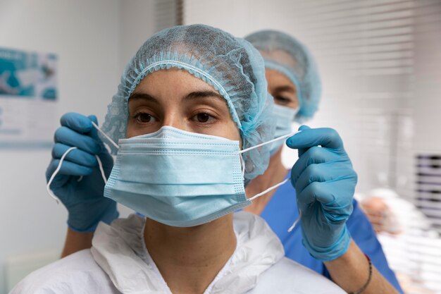 Nahaufnahme Krankenschwester, die Gesichtsmaske aufsetzt