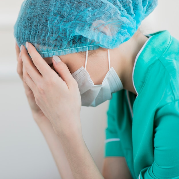 Nahaufnahme Krankenschwester mit Maske müde