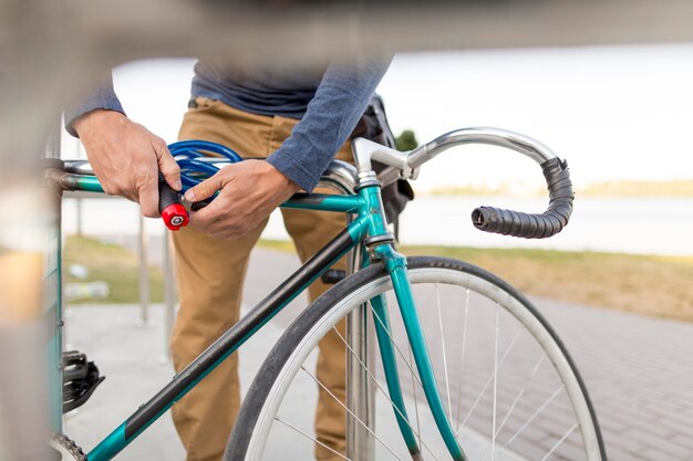 Nahaufnahme lässiger Mann, der sein Fahrrad sichert