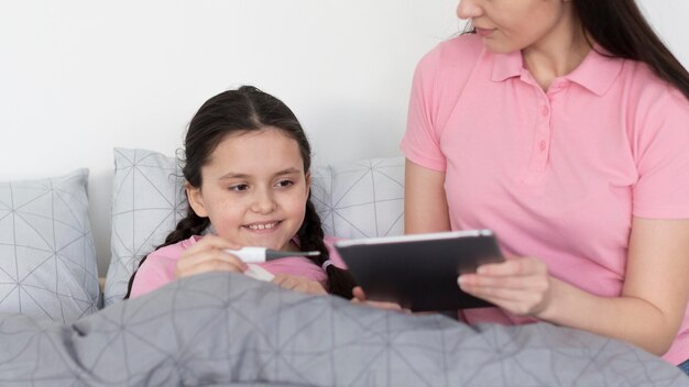 Nahaufnahme Mädchen im Bett mit Tablette