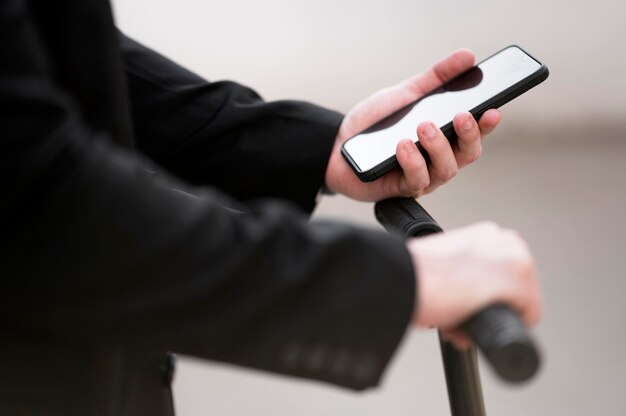 Nahaufnahme männlich mit Roller mit Handy