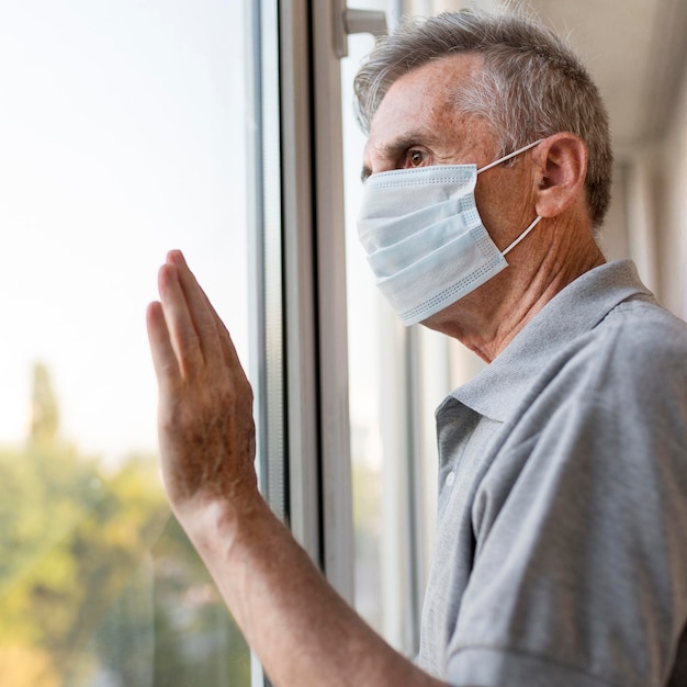 Kostenloses Foto nahaufnahme mann, der aus dem fenster schaut