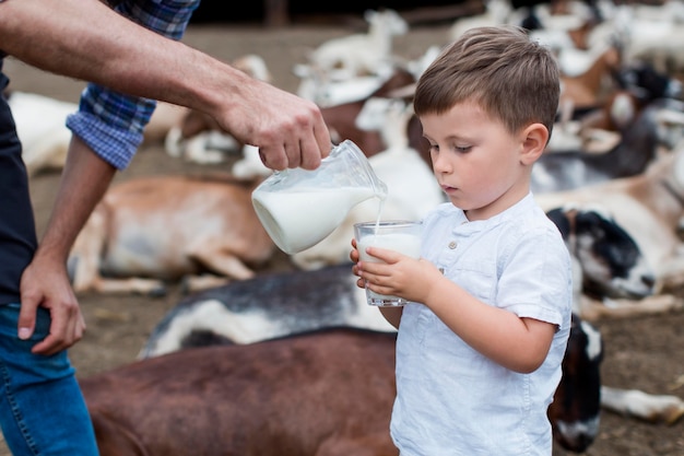 Kostenloses Foto nahaufnahme mann, der dem kleinen jungen milch gießt