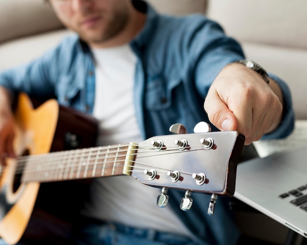 Nahaufnahme Mann, der lernt, wie man die Gitarre stimmt