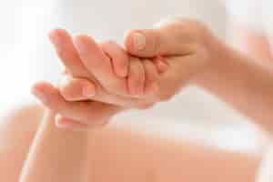 Kostenloses Foto nahaufnahme mutter, die babys hand hält