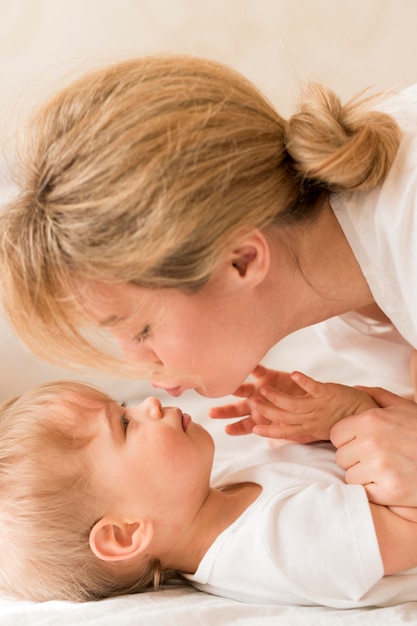 Nahaufnahme Mutter und Baby kuscheln im Bett