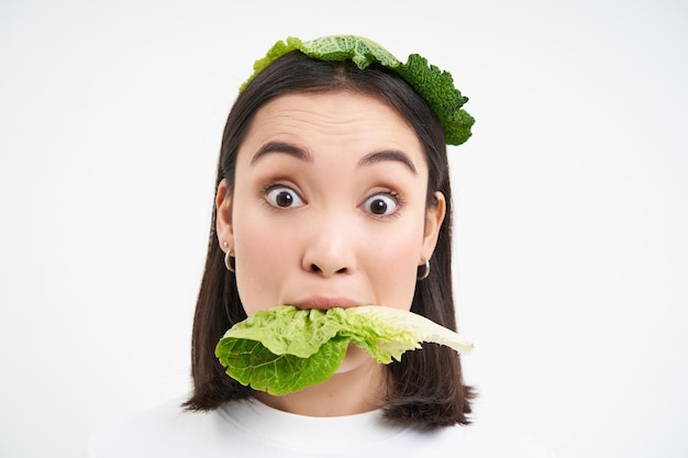 Kostenloses Foto nahaufnahme porträt einer lächelnden asiatischen frau, die salat isst, liebt kohl, vegetarierin und genießt rohes bio