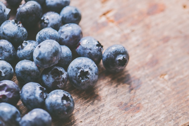 Nahaufnahme schoss frische reife Blaubeeren auf einem hölzernen Hintergrund