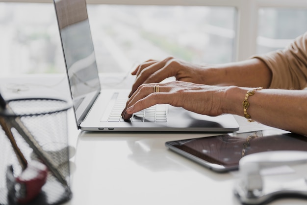 Nahaufnahme schoss von der Person, die auf Laptop schreibt