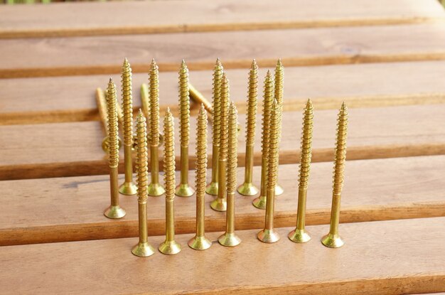 Nahaufnahme Schuss von goldenen Kreuzschrauben auf einem goldenen Tisch