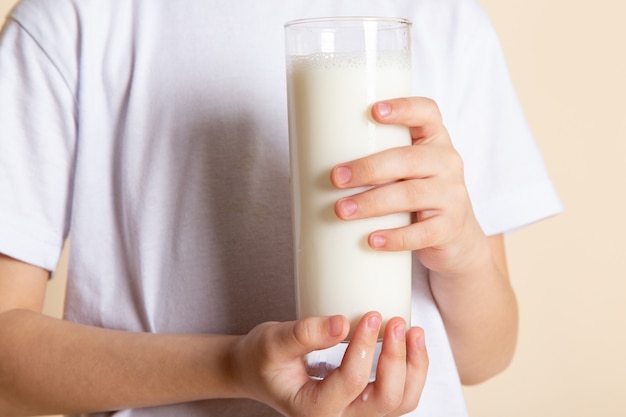 Nahaufnahme, sehen Sie kleines Kind, das Glas Milch im weißen T-Shrit hält