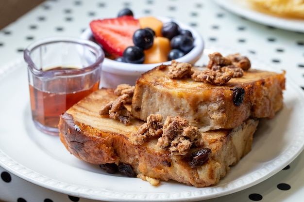 Nahaufnahme selektiver Fokusschuss von Toast mit Pflaumen und Früchten, Tee an der Seite