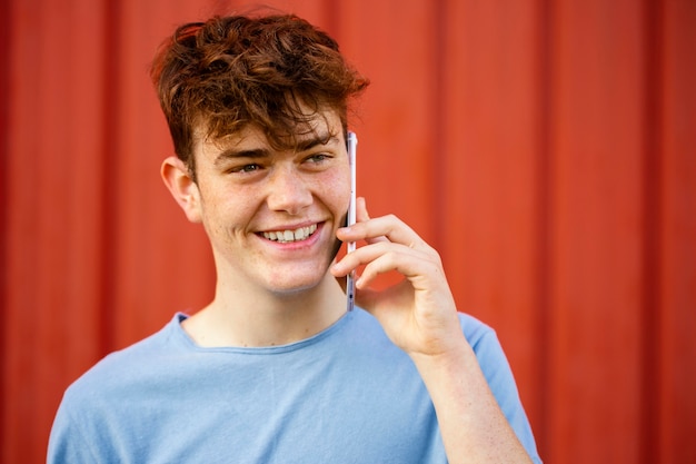 Nahaufnahme-Smiley-Junge, der am Telefon spricht