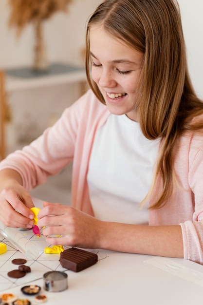 Kostenloses Foto nahaufnahme smiley mädchen, das mit lehm spielt