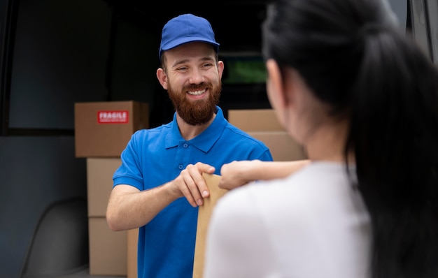 Nahaufnahme Smiley-Mann, der Paket liefert