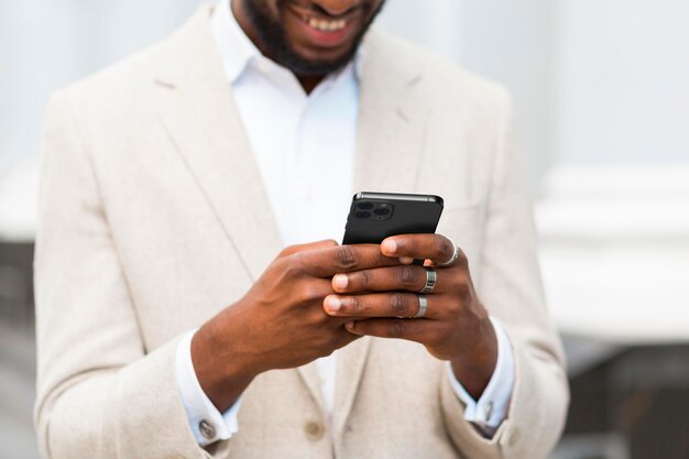 Nahaufnahme-Smiley-Mann, der Smartphone hält