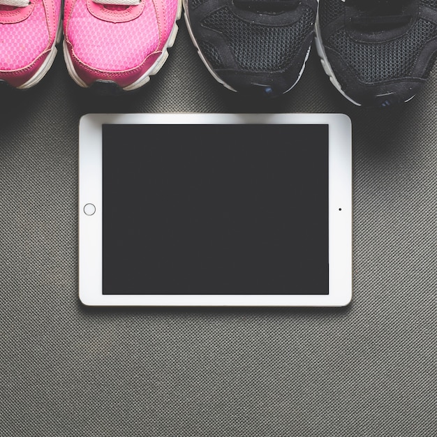 Nahaufnahme Tablette und Turnschuhe