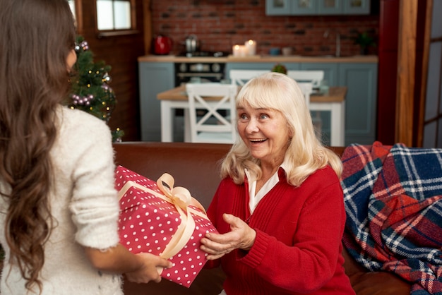 Nahaufnahme überraschte die Großmutter, die ein Geschenk empfängt