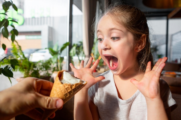 Nahaufnahme überraschtes Mädchen mit Eis