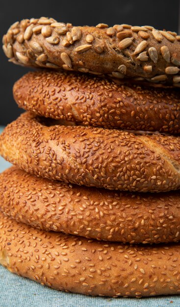 Nahaufnahme von Bagels auf blauer Oberfläche und schwarzem Hintergrund