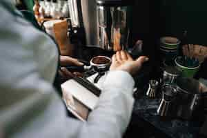 Kostenloses Foto nahaufnahme von barista-händen, die kaffee für kunden im café zubereiten