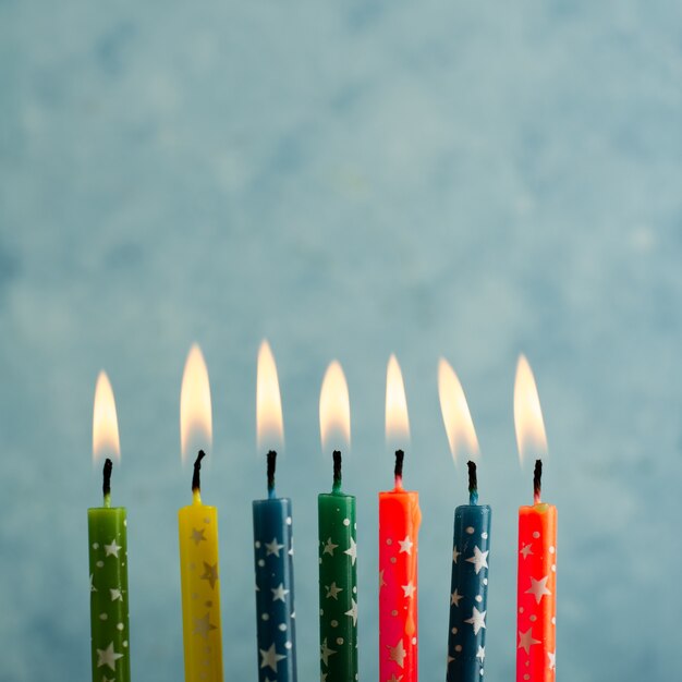 Nahaufnahme von beleuchteten mehrfarbigen Geburtstagskerzen