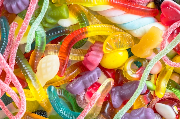 Nahaufnahme von bunten sortierten Gelewürmern und von anderen Süßigkeiten