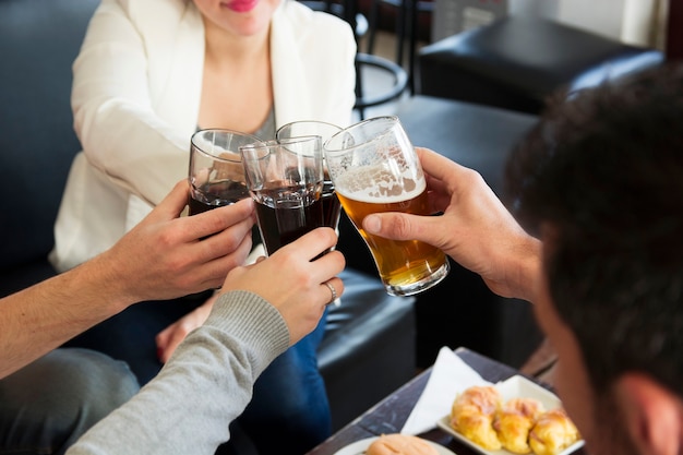 Nahaufnahme von den Freunden, die Gläser heiße Getränke in der Bar rösten