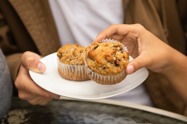 Nahaufnahme von den Freunden, die kleine Kuchen essen