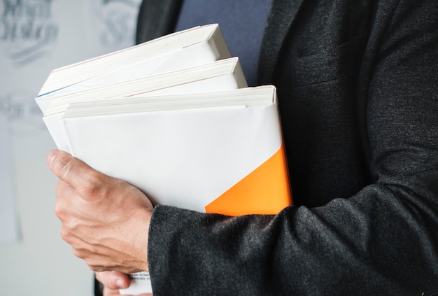 Kostenloses Foto nahaufnahme von den händen, die stapel bücher halten