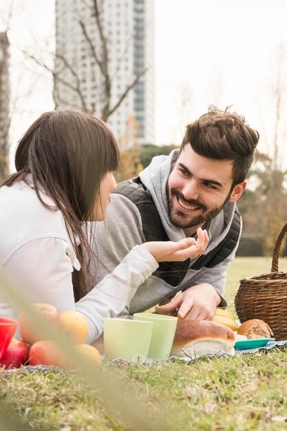 Nahaufnahme von den jungen Paaren, die einander im Picknick betrachten