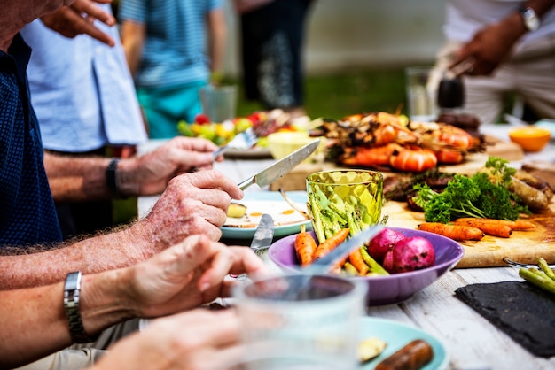 Nahaufnahme von den verschiedenen Leuten, die zusammen Grillpartei genießen