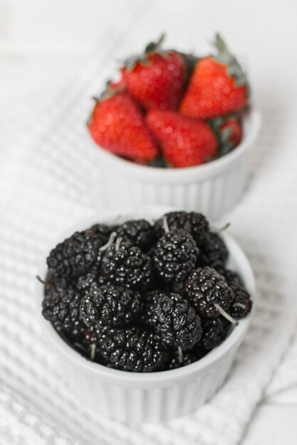 Nahaufnahme von Erdbeeren und von Maulbeeren in den Schüsseln