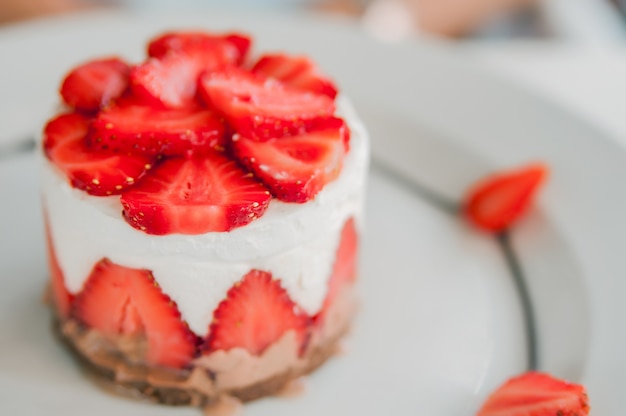 Nahaufnahme von Erdbeerkuchen mit frischen Erdbeeren auf Holzuntergrund. Hausgemachte Erdbeerkuchen. Käsekuchen mit Erdbeere