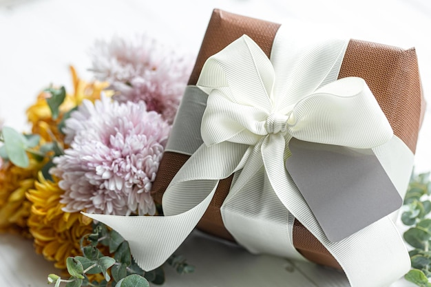 Nahaufnahme von festlicher Geschenkbox und Chrysanthemenblüten