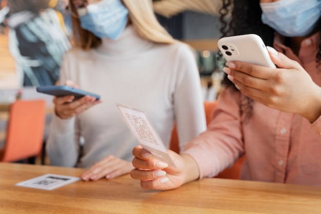 Nahaufnahme von Freunden, die das qr-Menü im Restaurant scannen