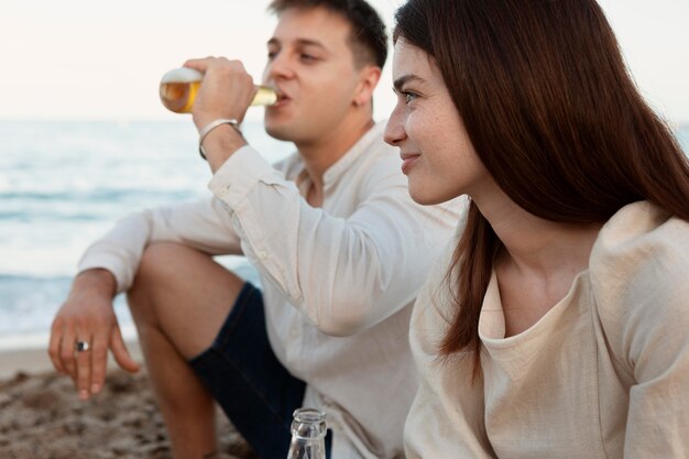 Nahaufnahme von Freunden, die zusammen am Strand sitzen