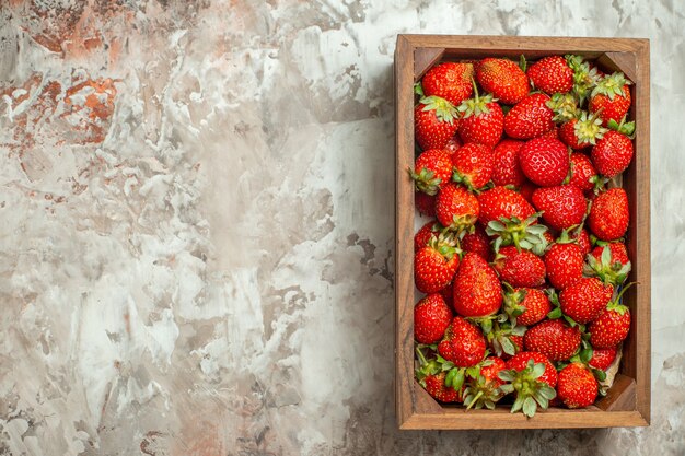 Nahaufnahme von frischen Erdbeeren in einer kleinen braunen Holzkiste