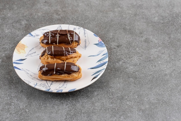 Nahaufnahme von frischen Schokoladen-Eclairs auf Teller