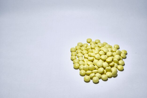 Nahaufnahme von gelben medizinischen Pillen auf weißem Hintergrund