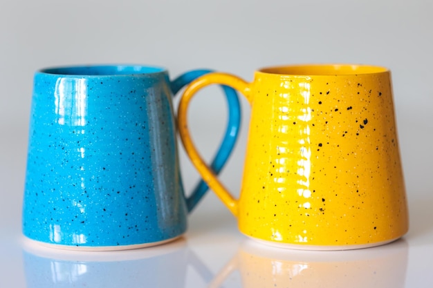 Kostenloses Foto nahaufnahme von gelben und blauen keramikbechern