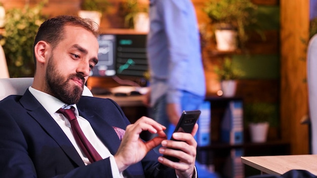 Nahaufnahme von Geschäftsmann, der das Telefon in der Hand hält. Modernes Büro