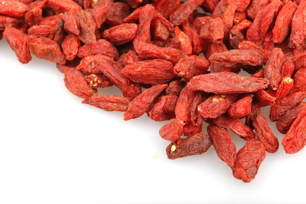 Nahaufnahme von getrockneten Goji-Beeren unter den Lichtern lokalisiert auf einem weißen Hintergrund