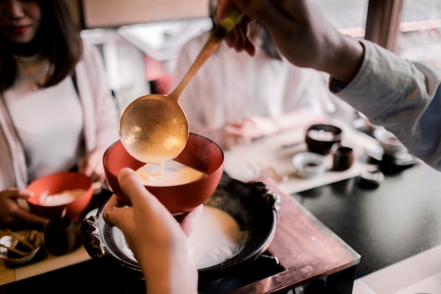 Nahaufnahme von Hand, die Essen in eine Schüssel gießt