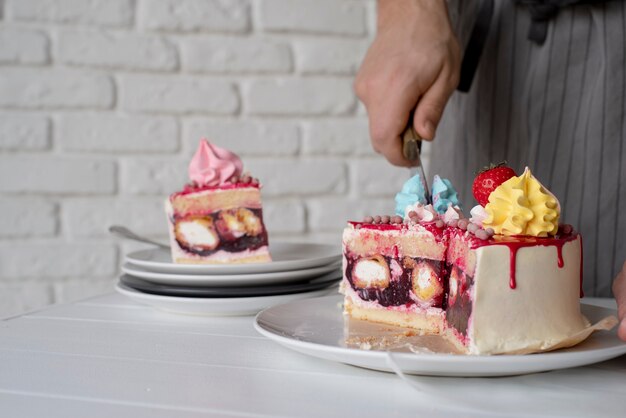 Nahaufnahme von Hand, die Kuchen mit Messer schneidet