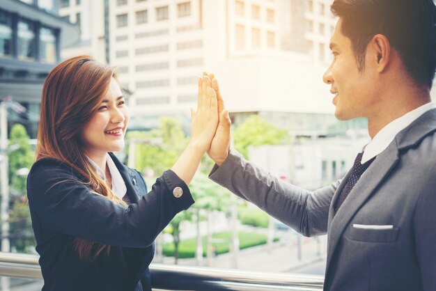 Nahaufnahme von Happy Business Menschen zeigen High Five Zeichen mit Team außerhalb.