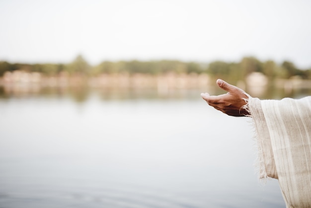 Nahaufnahme von Jesus Christus, der eine Hand um Hilfe reicht