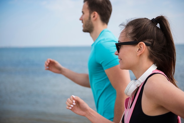 Nahaufnahme von jungen fitten Leuten, die durch das Meer joggen