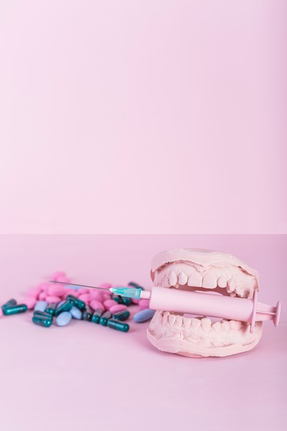 Nahaufnahme von Kapseln und von Pillen außer Zähnen formen mit Spritze